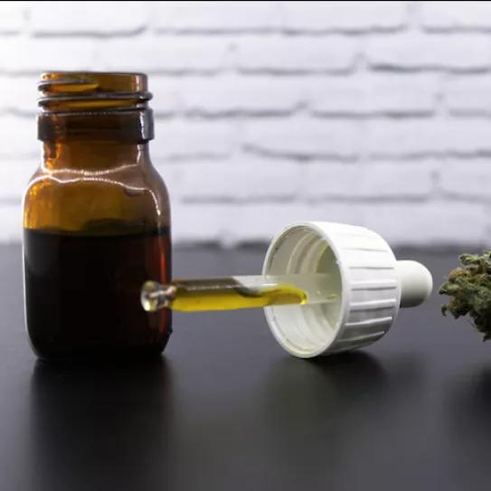 Frasco de CBD y cogollo de marihuana