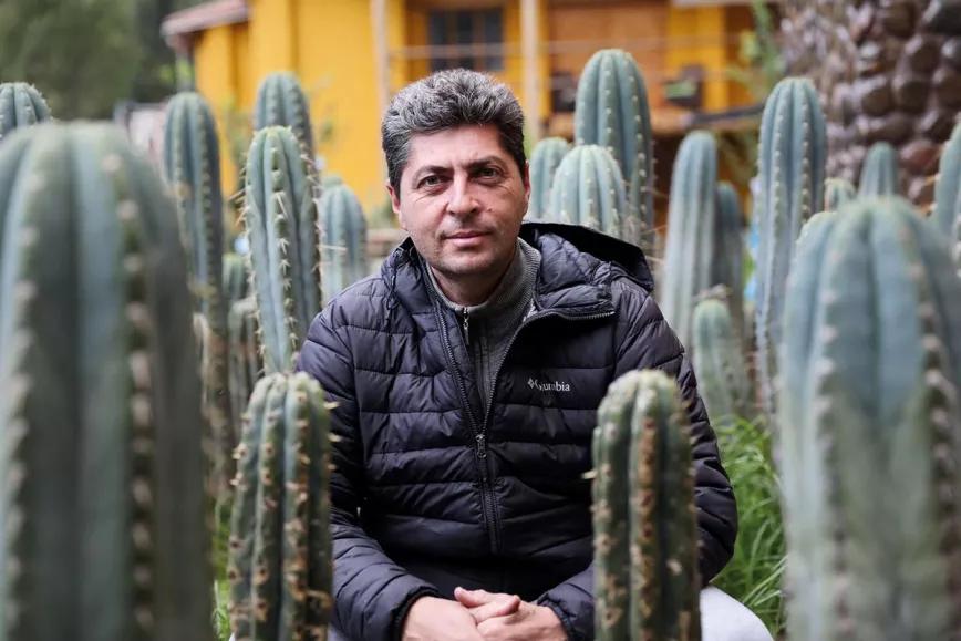 Sergey Baranov entre los cactus de huachuma del jardín de su casa.