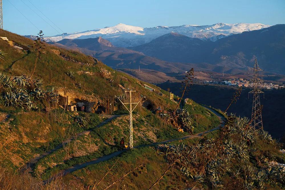 Dos de las varias elevaciones montañosas de la ciudad en las que se habita bajo tierra en las cuevas, arriba en el Barranco del Abogado y abajo en el Sacromonte.